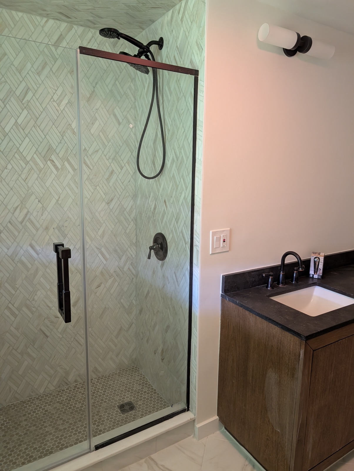 Bathroom remodel with herringbone marble tile shower and custom vanity